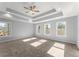 Main bedroom with carpet, tray ceiling, and multiple windows at 3170 Old Hwy 92 Dr, Acworth, GA 30102