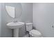 Clean bathroom with pedestal sink, toilet and oval mirror at 6397 Barker Station Walk, Sugar Hill, GA 30518