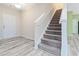 Bright entryway with stairs leading upstairs and light wood-look flooring at 6397 Barker Station Walk, Sugar Hill, GA 30518