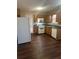 Galley kitchen with wood cabinets, laminate flooring, and white appliances at 3575 Oakvale Falls Ct, Decatur, GA 30034