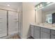 Bathroom with a glass shower door, double vanity, modern lighting, and ample counter space at 455 Payne Dr, Mcdonough, GA 30253