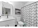 Modern bathroom featuring a stylish vanity, illuminated mirror, shelving, and a shower with a chevron patterned curtain at 160 Vanira Se Ave # A, Atlanta, GA 30315