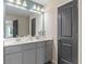 Double vanity bathroom with gray cabinets and a large mirror at 447 Payne Dr, Mcdonough, GA 30294