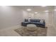 Finished basement with sectional sofa, ottoman, and light wood floors at 4840 Northway Dr, Atlanta, GA 30342