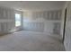 This is a spacious living room featuring fresh drywall with a window that lets in natural light at 2808 Lillian Ln, Douglasville, GA 30135