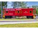 An old red train car, the Southern X223, with a water feature behind it, located in Douglasville, Georgia at 2808 Lillian Ln, Douglasville, GA 30135