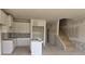 Unfinished kitchen with white cabinets, a center island, and access to stairs at 2816 Lillian Ln, Douglasville, GA 30135