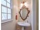 Powder room with pedestal sink and ornate mirror at 1401 Walcutts Nw Way, Marietta, GA 30064