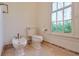 Classic white bathroom with pedestal sink and toilet, featuring a window overlooking the garden at 1401 Walcutts Nw Way, Marietta, GA 30064