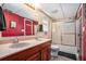 Bathroom with dual sinks, cherry cabinets, and a glass enclosed shower at 230 Cobblestone Ln, Mcdonough, GA 30252