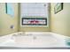 Bathroom with a relaxing soaking tub, mosaic-style window, and elegant fixtures at 230 Cobblestone Ln, Mcdonough, GA 30252