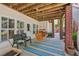 Covered patio with a wooden swing and striped rug at 3745 Homestead Ridge Dr, Cumming, GA 30041