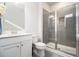 Clean bathroom featuring a glass shower, a modern vanity, sleek tile, and contemporary fixtures at 200 Wallace St, Fayetteville, GA 30214