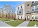 Modern townhome featuring brick accents, a well-kept lawn, and manicured shrubs at 200 Wallace St, Fayetteville, GA 30214