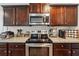 Kitchen boasts dark brown cabinets, stainless steel appliances, and granite countertops at 218 Cynthia Ct, Dallas, GA 30157