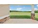 Covered porch with stone pillars offering a view of open fields at 615 Henderson Mill Rd, Covington, GA 30014