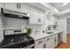 Updated kitchen with white subway tile backsplash, gas range, and white cabinets at 6851 Roswell Rd # N-20, Sandy Springs, GA 30328