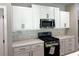 Well-equipped kitchen featuring white cabinets, stainless steel microwave and gas range at 15 Cambridge Ln, Dallas, GA 30157