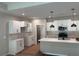 Modern kitchen with white cabinets, stainless steel appliances, pendant lighting, and a large center island awaiting finishing touches at 15 Cambridge Ln, Dallas, GA 30157