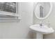 Small powder room with pedestal sink and circular mirror at 2155 Washington Dr, Douglasville, GA 30135