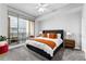 Bright bedroom with a large window leading to the balcony and neutral colored carpet at 565 Peachtree Ne St # 804, Atlanta, GA 30308