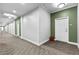 Long hallway with grey carpet and olive green walls leading to apartment door at 565 Peachtree Ne St # 804, Atlanta, GA 30308