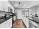 Modern kitchen with stainless steel appliances, white cabinets, and black countertops at 565 Peachtree Ne St # 804, Atlanta, GA 30308