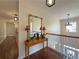 Upper hallway with console table, mirror, and wood floors at 1588 School House Run, Dacula, GA 30019