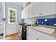 Bright laundry room with white cabinets and granite countertops at 3173 Woodrow Ne Way, Brookhaven, GA 30319