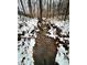 Small creek running through a snowy wooded area at 1544 Bullard Rd, Powder Springs, GA 30127