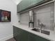 Modern laundry room with green cabinets, a farmhouse sink, and a water filtration system at 1544 Bullard Rd, Powder Springs, GA 30127
