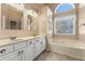 Main bathroom with double vanity, garden tub, and window at 2490 Insdale Nw Trce, Acworth, GA 30101