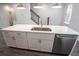 Modern kitchen island with white shaker cabinets, quartz countertops, and stainless steel sink at 5215 Riden Ct, Buford, GA 30518