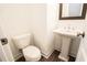 Small powder room with pedestal sink, toilet, and wood-look floors at 5215 Riden Ct, Buford, GA 30518