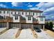 Rear view of townhouses showcasing private decks, garages, and parking area at 5215 Riden Ct, Buford, GA 30518