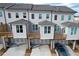 Rear view of townhouses showcasing private decks, garages, and parking area at 5215 Riden Ct, Buford, GA 30518