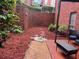 Private backyard patio area with brick flooring, mulch ground covering, and privacy fence at 6851 Roswell Rd # J1, Atlanta, GA 30328