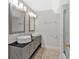 Bright bathroom features a double sink vanity, framed mirrors, modern lighting, and tiled flooring at 6851 Roswell Rd # J1, Atlanta, GA 30328