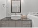 Bathroom including a vanity with modern sink, framed mirror, and a washer and dryer at 6851 Roswell Rd # J1, Atlanta, GA 30328