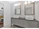 Modern bathroom features a double sink vanity, framed mirrors, modern lighting, and white tile flooring at 6851 Roswell Rd # J1, Atlanta, GA 30328