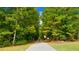 Scenic walking path lined with lush greenery and trees in a peaceful community setting at 13541 Whitman Ln, Covington, GA 30014