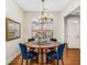 Formal dining room with a round table, blue chairs, and chandelier at 1045 Brook Knoll Ln # 401, Cumming, GA 30041