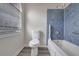 A bathroom features a toilet, bathtub with blue tile surround, and a window at 148 Shady View Pl, Lawrenceville, GA 30044