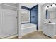 Bathroom with a tub and shower, single vanity, and a window providing natural light at 148 Shady View Pl, Lawrenceville, GA 30044