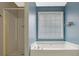 A bathroom featuring a standalone shower and a soaking tub next to the window at 148 Shady View Pl, Lawrenceville, GA 30044