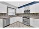 Modern kitchen with stainless steel appliances, white cabinets, mosaic backsplash, and tile flooring at 148 Shady View Pl, Lawrenceville, GA 30044
