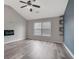 Living room with vaulted ceilings and a modern electric fireplace with custom display shelving and vinyl wood flooring at 148 Shady View Pl, Lawrenceville, GA 30044
