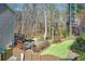 A secluded backyard has a stone patio, lawn, and a hot tub under an upper level deck at 322 Berkshire Trce, Canton, GA 30115