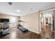 Home gym area in basement features fitness equipment, a TV and wood floors at 322 Berkshire Trce, Canton, GA 30115