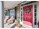 Inviting entryway featuring a vibrant red door, brick facade, and charming porch decor at 322 Berkshire Trce, Canton, GA 30115